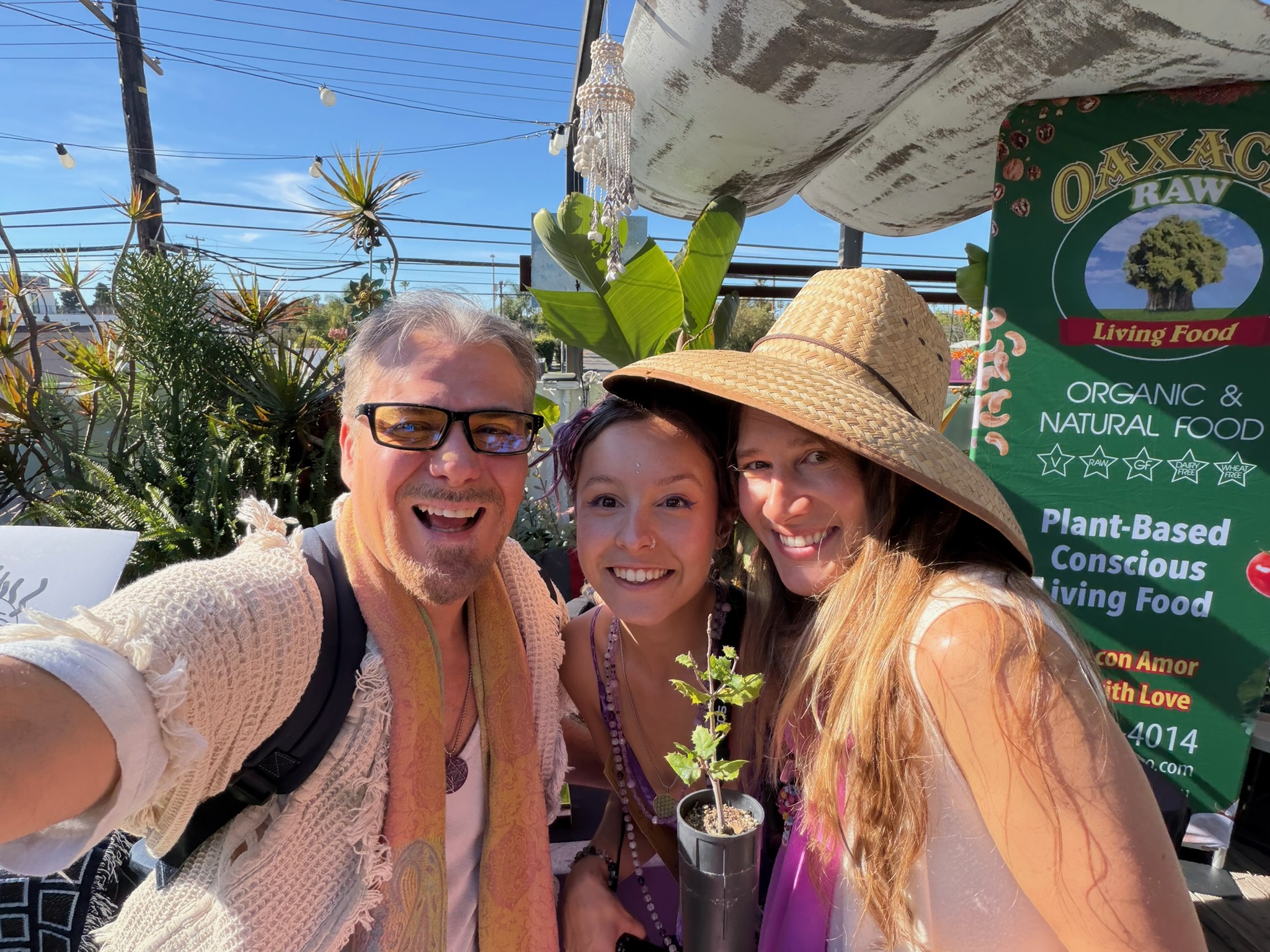 Sanctuary members at a plant-based food stall in the neighborhood, holding a seedling